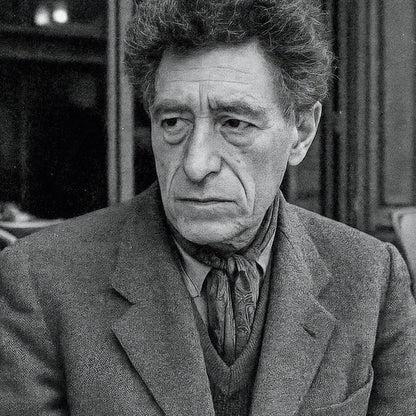 Black and white portrait of a man wearing a coat and patterned tie.