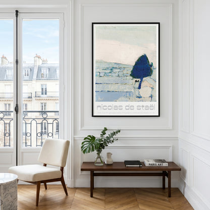 A framed art print featuring an abstract landscape with a dark blue tree and the text 'Nicolas de steel' is displayed on a white paneled wall in a bright room with a window, chair, and bench.