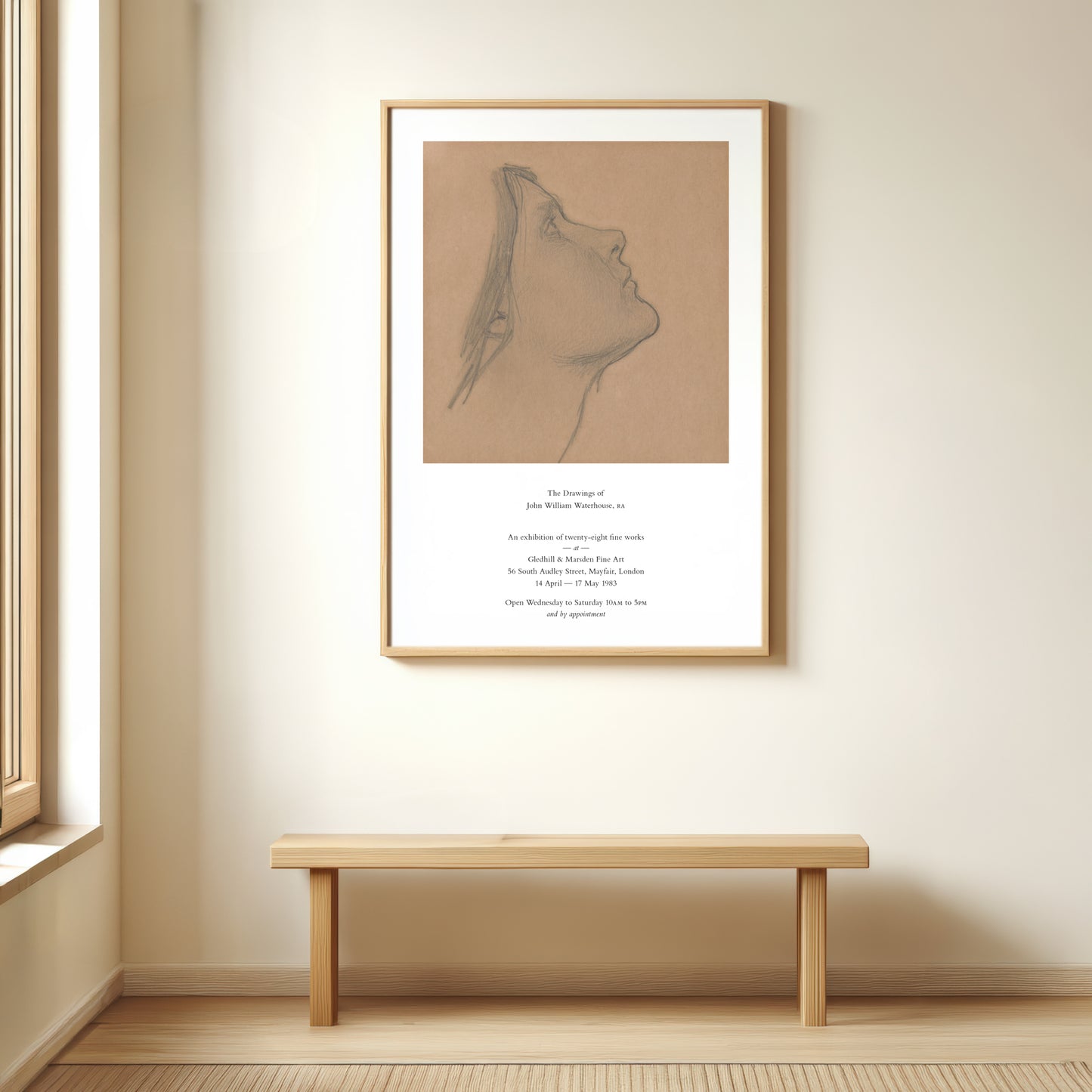 Framed artwork on a wall above a wooden bench in a room with a window.