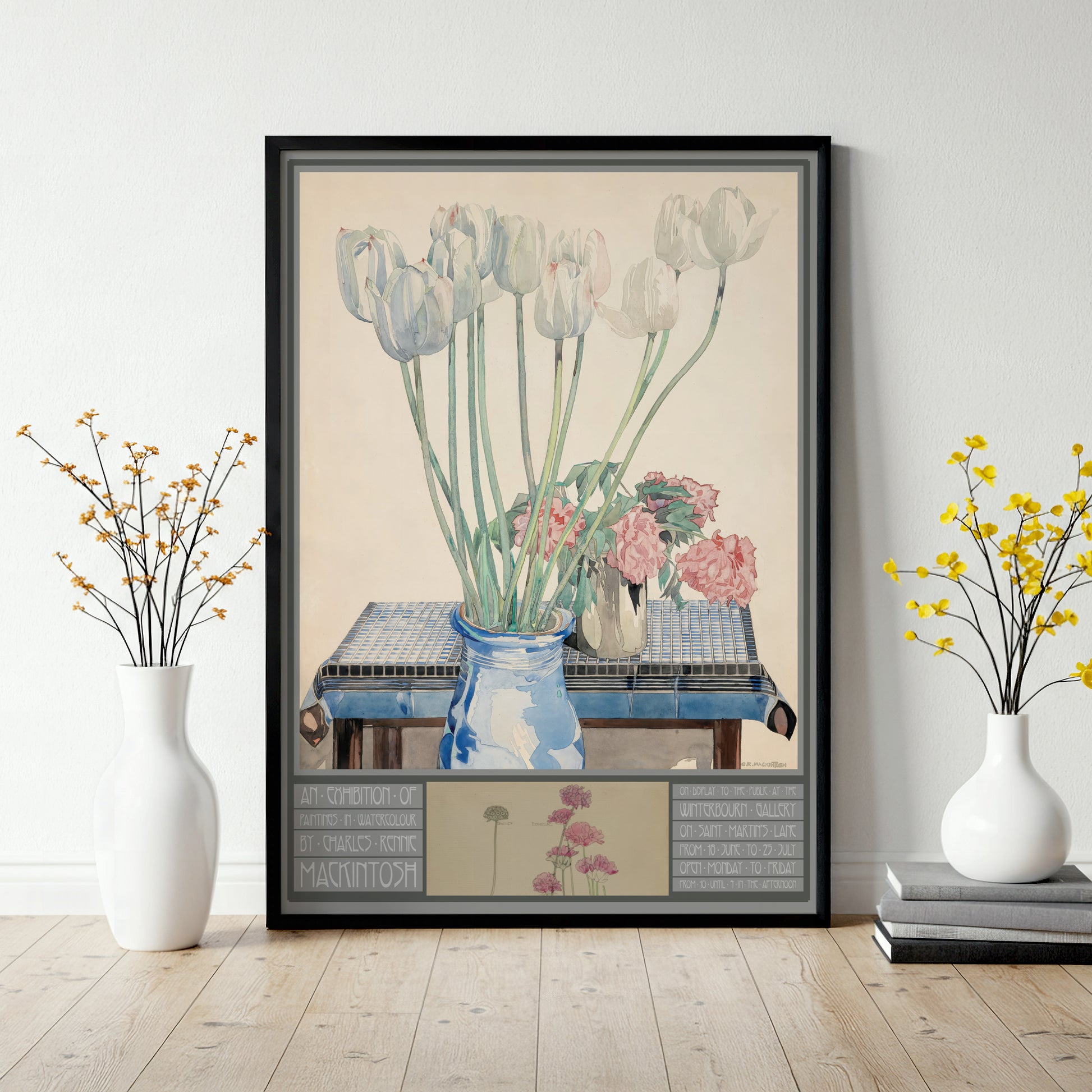 Framed artwork of flowers on a table with decorative elements, displayed in a room.